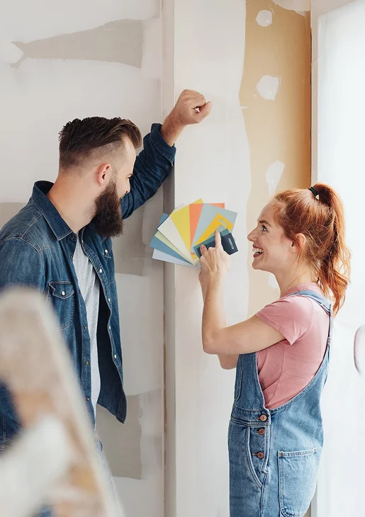 Un couple souriant choisit des couleurs de peinture parmi des échantillons sur un mur inachevé à Argy près de Châteauroux dans l'Indre 36