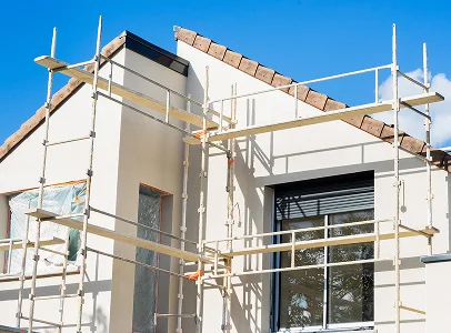Échafaudages installés devant la façade blanche d'une maison moderne en rénovation sous un ciel bleu à Argy près de Châteauroux dans l'Indre 36